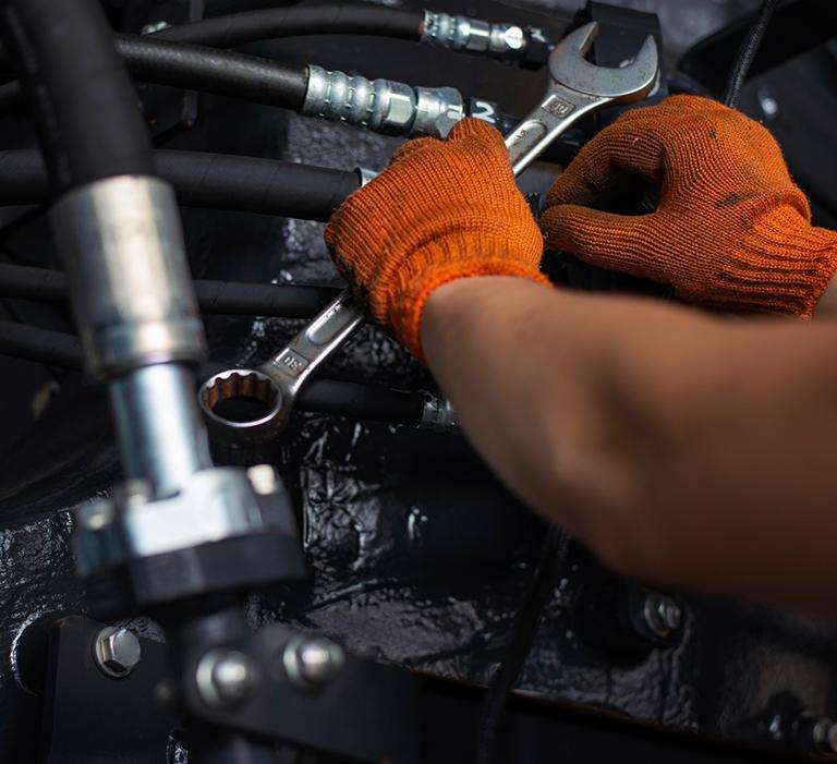 Osoba w rękawiczkach korzysta z klucza płaskiego