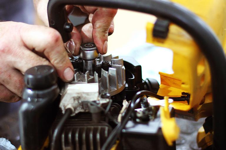 Osoba naprawia maszynę